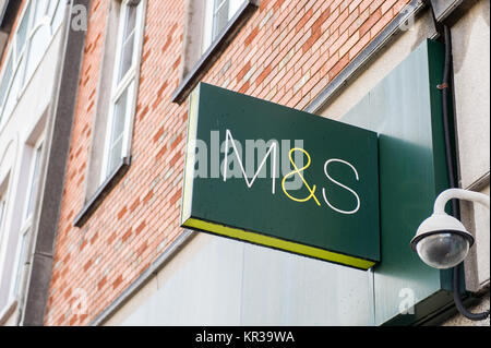 Marks & Spencer sign on a wall in Cork, Ireland with a CCTV camera and copy space. Stock Photo