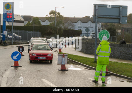 Workman with a stop and go sign controlling traffic at roadworks in Skibbereen, Ireland with copy space. Stock Photo