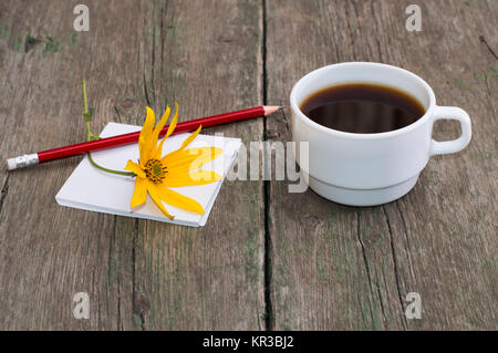 still life cup of coffee, paper, pencil and yellow flower, greeting card Stock Photo