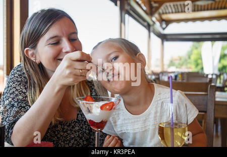 Mother feeds daughter Stock Photo