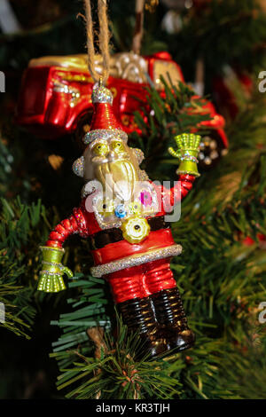 Robot Santa Christmas ornament on green Christmas tree with firetruck ornament in background - selective focus Stock Photo