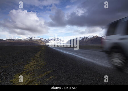 Offroad car on a straight road from the mountains Stock Photo
