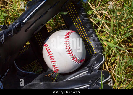 Baseball in glove over grass Stock Photo