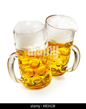 Two pint mugs of glowing golden frothy cold beer viewed high angle over white conceptual of the annual German Oktoberfest Stock Photo