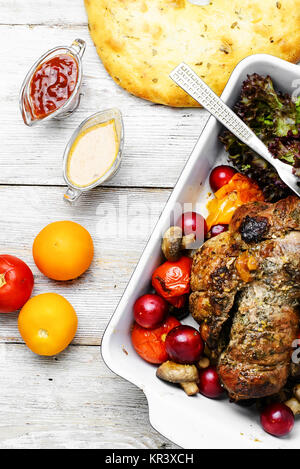 Twisted meatloaf with veal in plum sauce and vegetables in baking dish Stock Photo