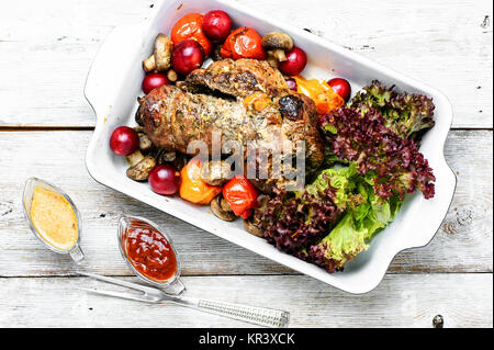 Twisted meatloaf with veal in plum sauce and vegetables in baking dish Stock Photo