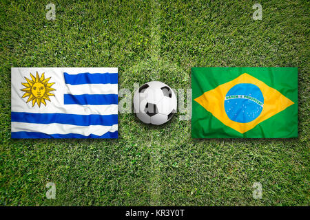 Uruguay vs. Brazil flags on soccer field Stock Photo