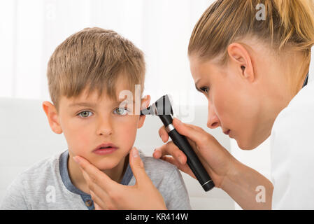 Doctor Examining Boy's Ear Stock Photo