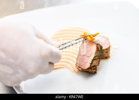 Chef garnishing meat dish Stock Photo
