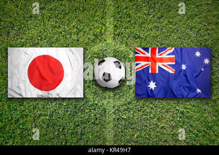 Japan vs. Australia flags on soccer field Stock Photo