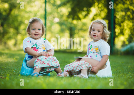 The two little baby girls hanging upside down Stock Photo