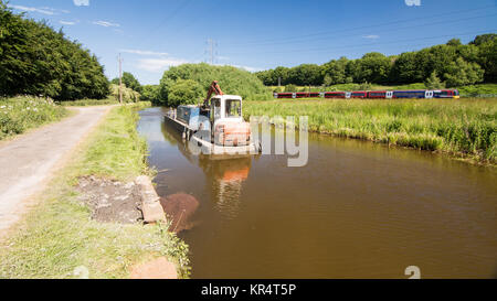 Leeds, England - June 30, 2015: A Northern Rail Class 333 commuter train runs alongside the Leeds and Liverpool Canal near Shipley in West Yorkshire's Stock Photo