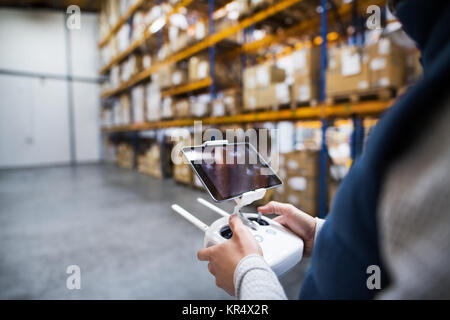 Man with tablet and drone controller in a warehouse. Stock Photo