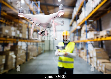 Man with drone in a warehouse. Stock Photo