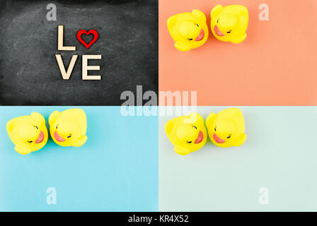 Pair of yellow rubber ducks isolated over colorful background, love concept Stock Photo