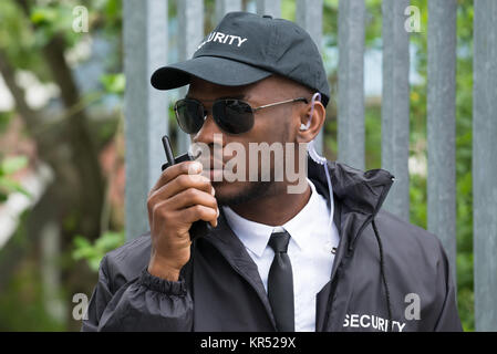 Security Guard Using Walkie-Talkie Stock Photo