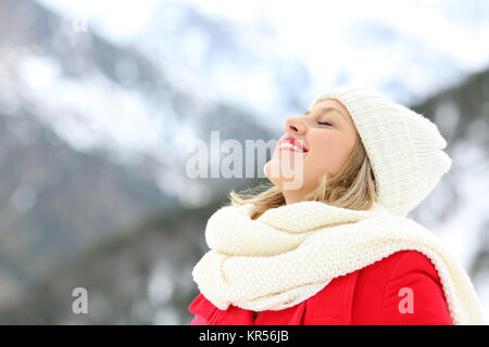 Happy woman breathing deep fresh air in winter on holidays in a snowy mountain Stock Photo