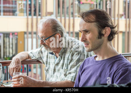 Caucasian father and son sitting at the cafe, drinking Turkish tea. Stock Photo