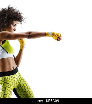 Boxer woman in yellow bandages making direct hit. Photo of sporty african woman during boxing on white background. Dynamic movement. Side view Stock Photo