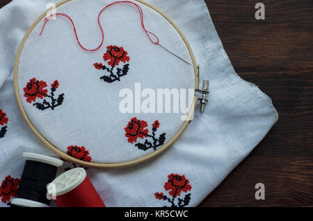 White cloth with hand-embroidered with a cross in the hoop Stock Photo