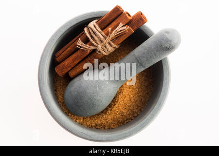 Cinnamon sticks with pure cane brown sugar in mortar Stock Photo