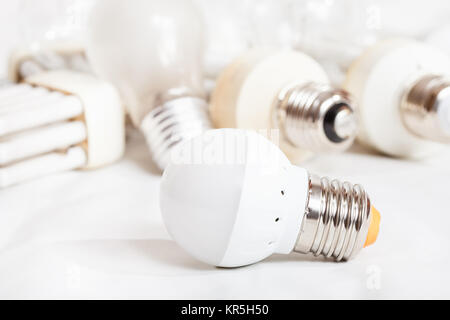 energy saving LED lamp and several old light bulbs Stock Photo