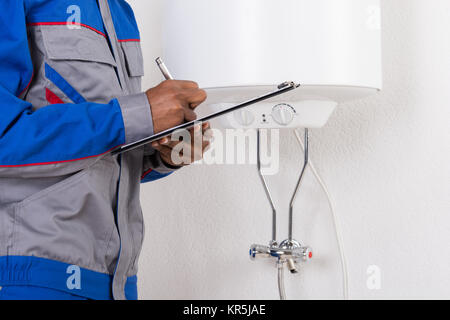Plumber Writing On Clipboard Stock Photo