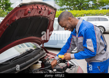 Mechanic Using Multimeter To Check Car Battery Stock Photo