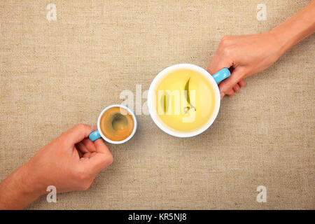 Two hands with espresso coffee and green tea cups Stock Photo