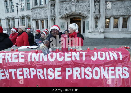 London, UK. 18 December 2017. Demonstration against Joint Enterprise outside the Supreme Court. Demonstration outside the Supreme Court, Parliament Square, Westminster, to highlight the 800 innocent people held in prison despite the Supreme Court's judgement in February 2016 that the Joint Enterprise, or Common Purpose Law, has been wrongly interpreted for 30 years. The demonstrators wore Santa hats and sang carols and handed out leaflets explaining their cause. Credit: Peter Hogan/Alamy Live News Stock Photo