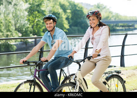 Couple On Bicycles Ride In The Park Stock Photo