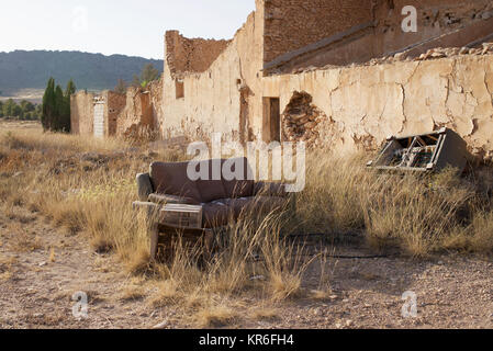 Abandoned building with furniture dumped outside in the countryside Stock Photo