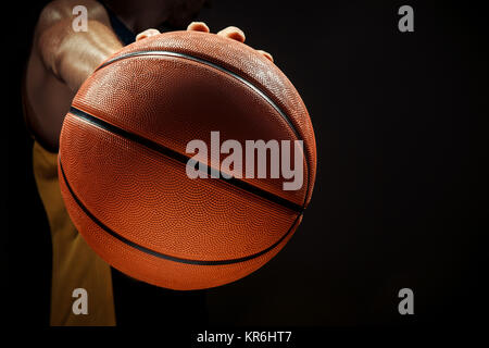 Silhouette view of a basketball player holding basket ball on black background Stock Photo