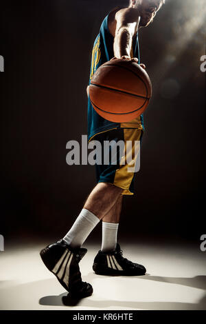 Silhouette view of a basketball player holding basket ball on black background Stock Photo