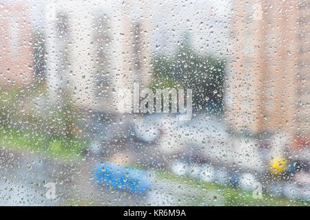 view of raindrops on windowpane of urban house Stock Photo