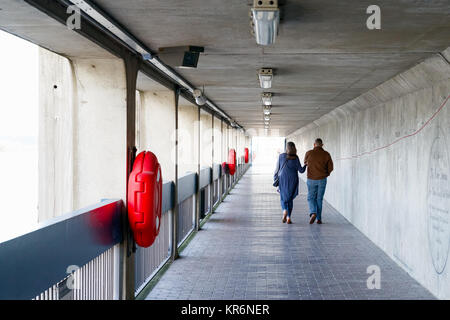 London, UK - June 13, 2017 - A couple walking on Thames Barrier passageway, part of the Thames Path national trail Stock Photo