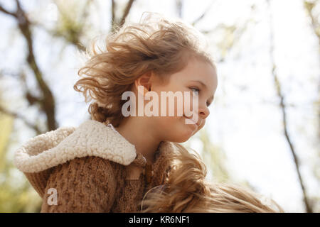 Little adorable girl sitting on her mother's shoulders. Autumn outdoor. Stock Photo