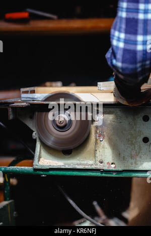 Carpenter using circular saw cutting wooden board in wood workshop Stock Photo