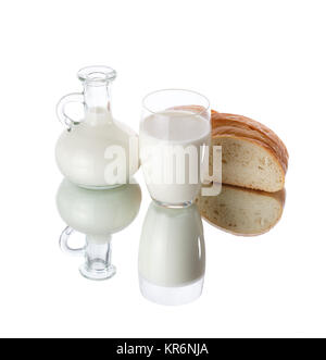 Jug and glass of milk with a loaf of bread isolated on white background. Stock Photo