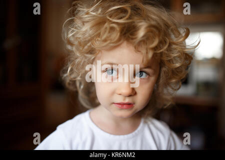 Portrait of adorable little blonde girl with curly hair. Stock Photo