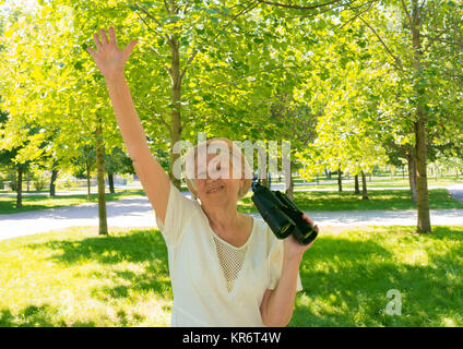 Senior woman with binoculars in park Stock Photo