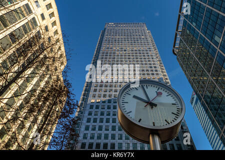 Giant clock  at Canary Wharf dominates the foreground in front of No 1 Canada Square , Canary Wharf, London Stock Photo