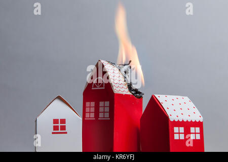 House fire concept. Toy house with flames Stock Photo