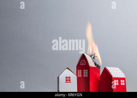 House fire concept. Toy house with flames Stock Photo