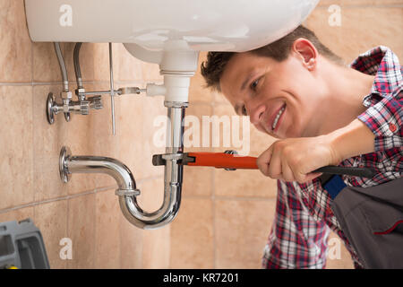 Plumber Fixing Sink Pipe With Adjustable Wrench Stock Photo