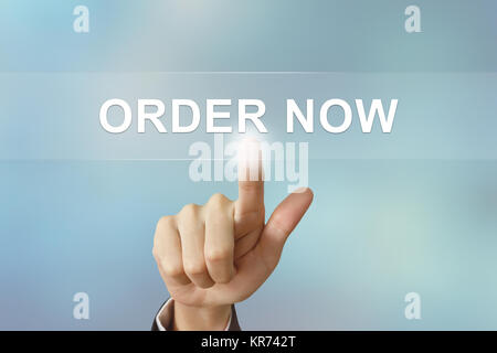 business hand clicking order now button on blurred background Stock Photo