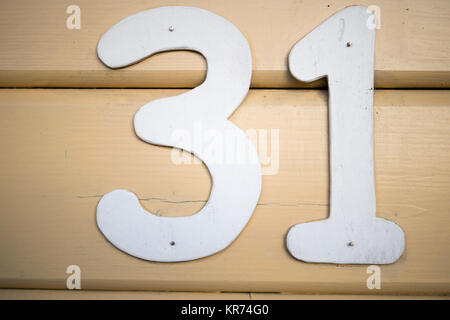nailed house number 31 in white on a wooden house wall Stock Photo