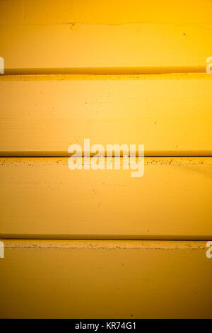 Wooden house wall painted in yellow in detail Stock Photo