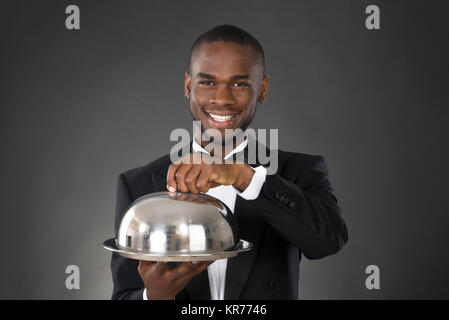 Waiter Serving Meal In Cloche Stock Photo