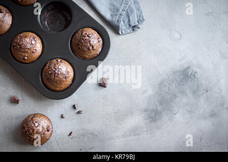 Double Chocolate Muffins with Chocolate Drops in bakeware. Homemade chocolate pastry for breakfast or dessert. Stock Photo